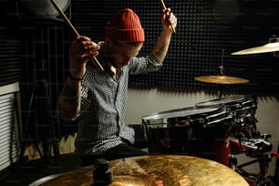 energetic caucasian drummer man professionally play on drums, he enjoy performing music in studio, preparing for concert. rock and roll, music, instruments concept