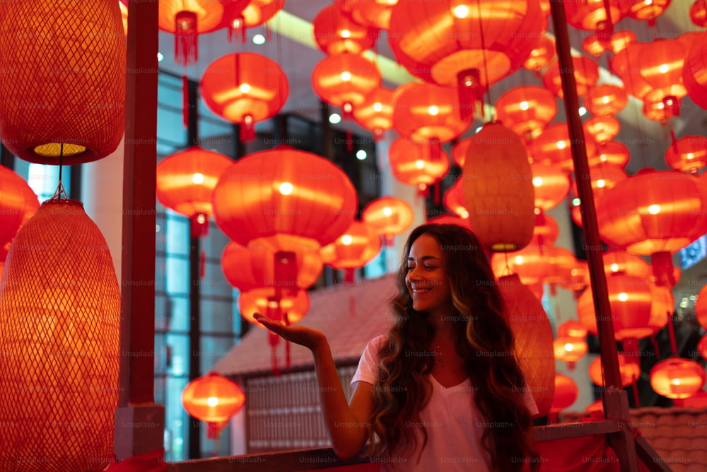 중국 설날 춘지를 위해 장식된 전통적인 붉은 등불을 즐기는 행복한 관광객 여성. 베이징의 문화 아시아 축제.
