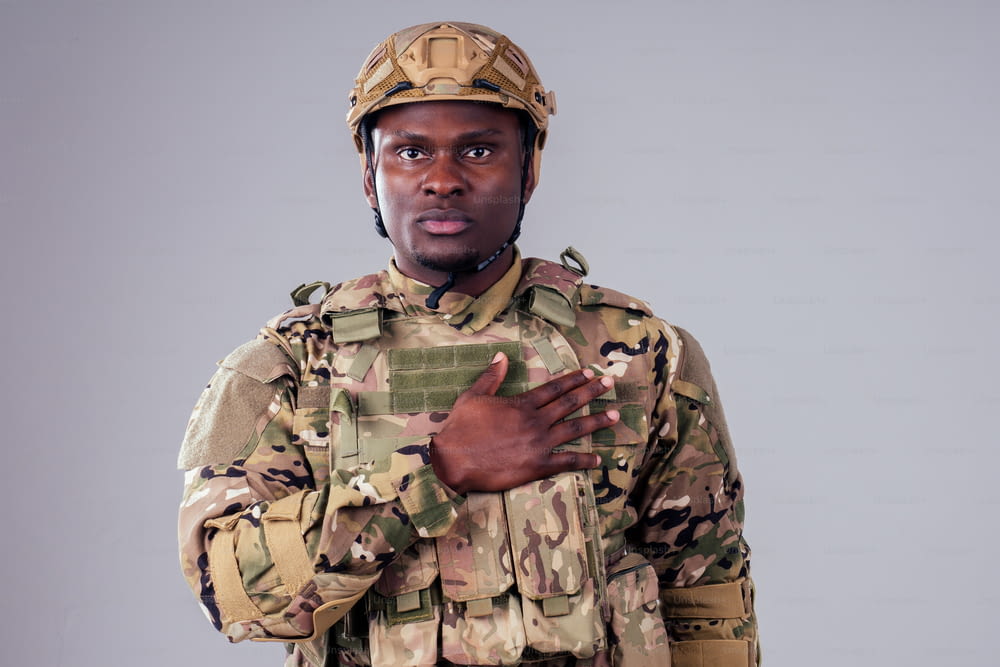 Soldado afroamericano con los brazos cruzados de pie en un estudio blanco
