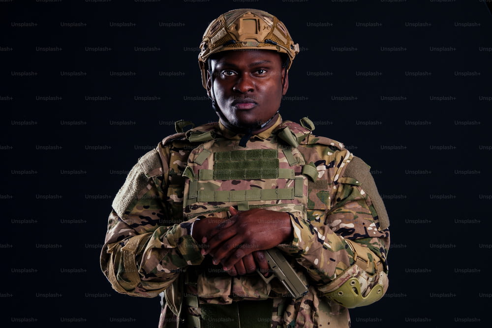 하얀 스튜디오에 서 있는 팔짱을 낀 아프리카계 미국인 군인