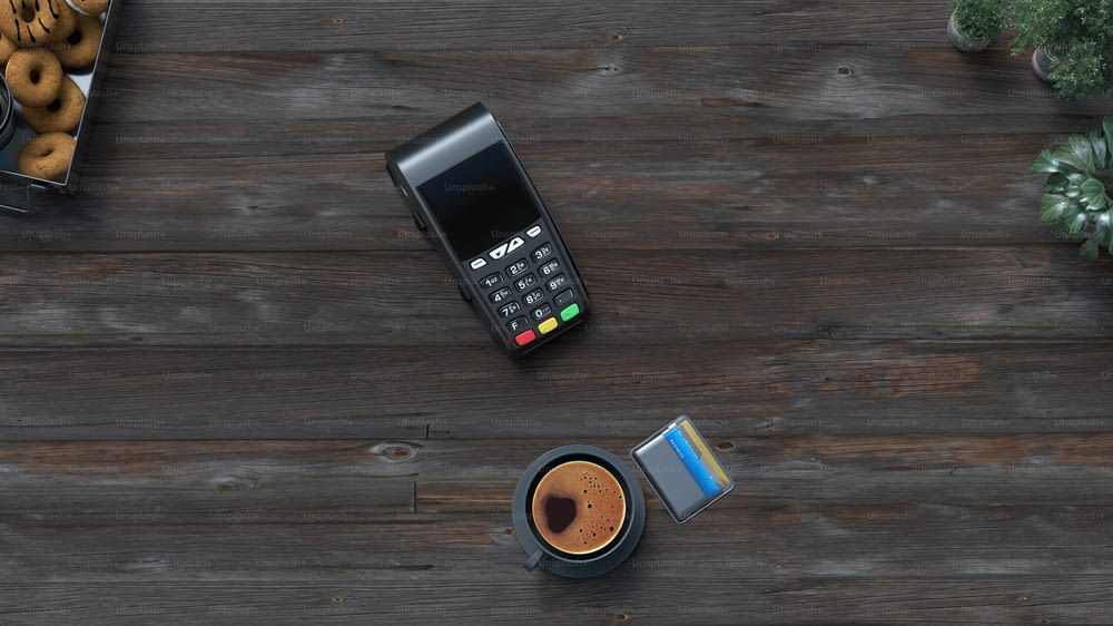 ein Handy, das auf einem Holztisch neben einer Tasse Kaffee sitzt
