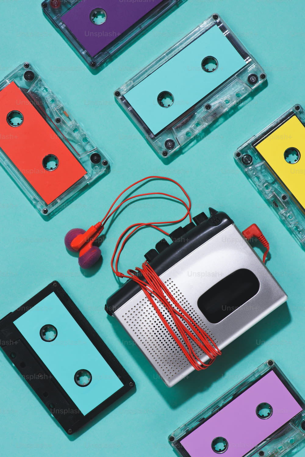 flat lay with colorful retro audio cassettes, cassette player and earphones isolated on blue
