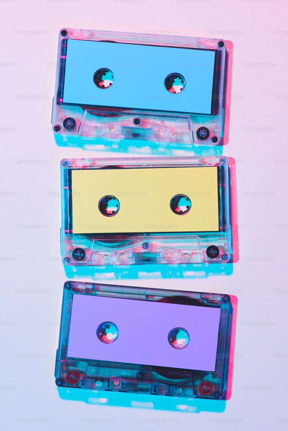 Vista superior de casetes de audio coloridos dispuestos sobre fondo púrpura