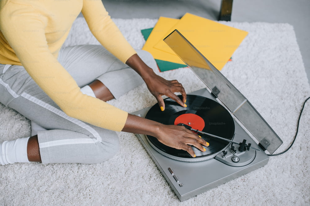 visão cortada da mulher afro-americana usando o toca-discos no tapete