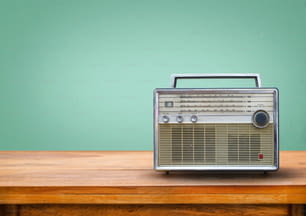 Old retro radio on table with vintage green eye light background