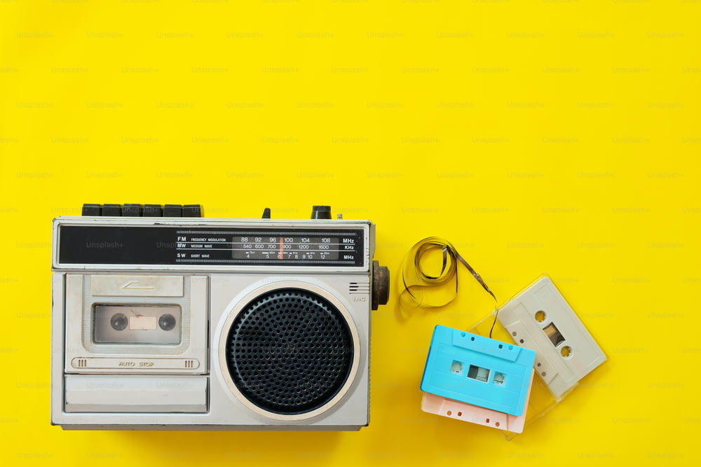 빈티지 라디오와 카세트 플레이어는 노란색 배경에 있고, 평평하게 놓여 있고, 평면도에 있다. 레트로 기술