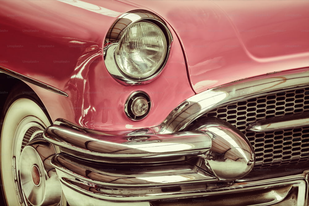 Immagine in stile retrò di una parte anteriore di un'auto d'epoca rosa