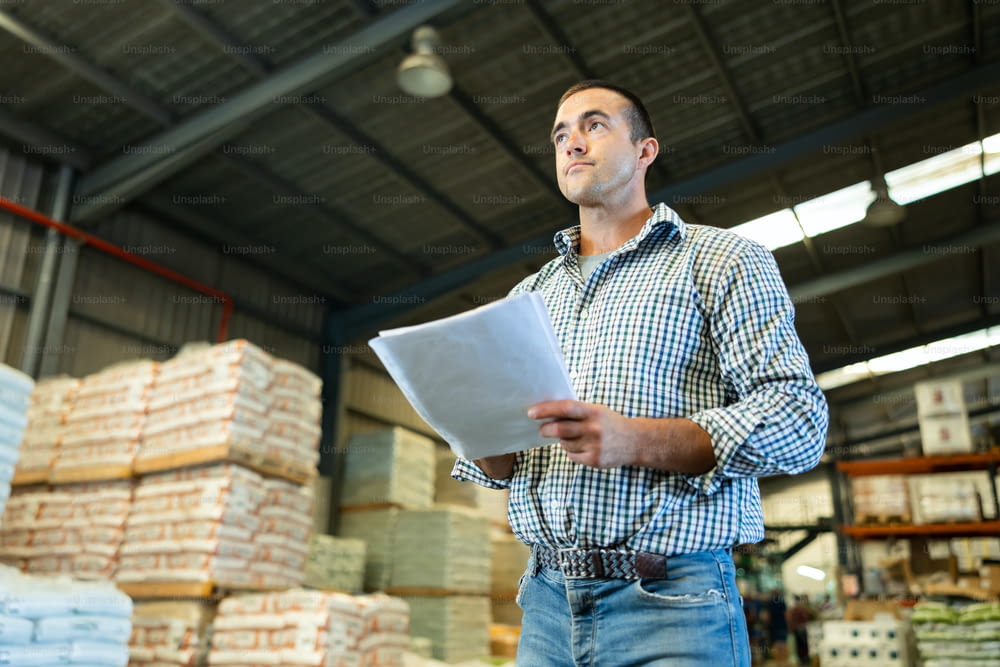 Man inspecting warehouse to check quantity of goods on shelves. Man examining storehouse.