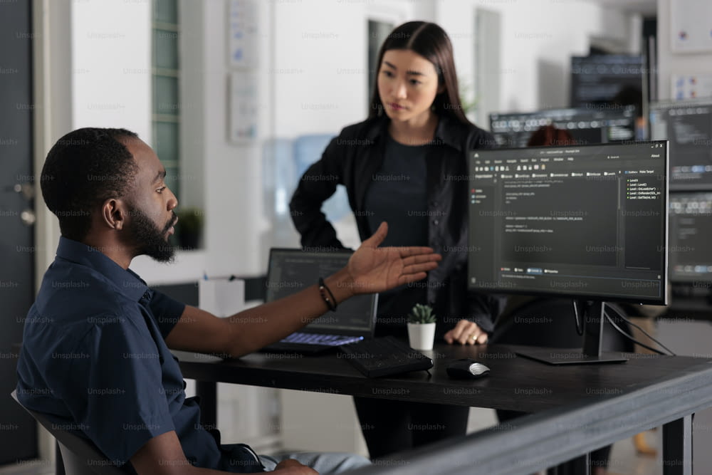 Diverse team of software developer developing html code and cloud computing in it development agency. African american system engineer typing on keyboard to create artificial intelligence script.
