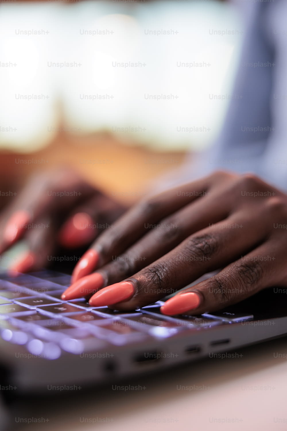 African american company remote worker typing message on laptop keyboard, close view on manicured nails. Young corporate employee, writing email on computer, focus on hands
