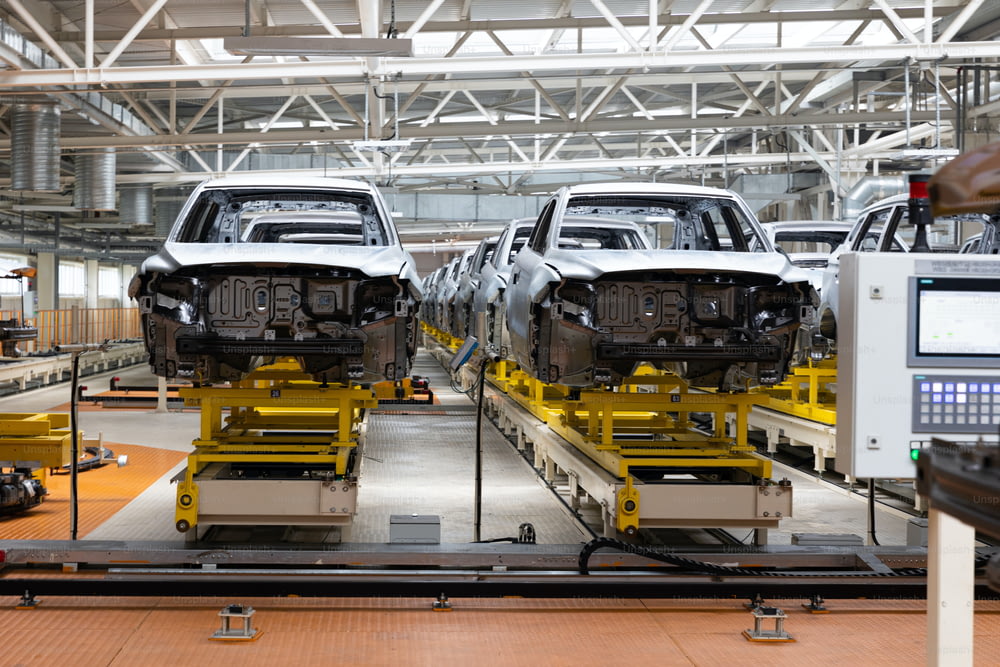 Photo of automobile production line. Welding car body. Modern car assembly plant. Auto industry. Interior of a high-tech factory.