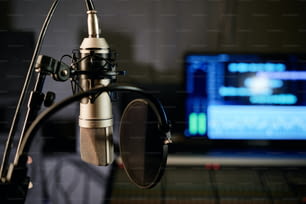 Horizontal sem pessoas foco seletivo tiro de microfone com filtro pop de disco e console de mixagem no estúdio de gravação moderna