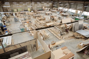 作業用品のある作業台で構成される職場を持つ現代的な家具工場の大きなワークショップの内部