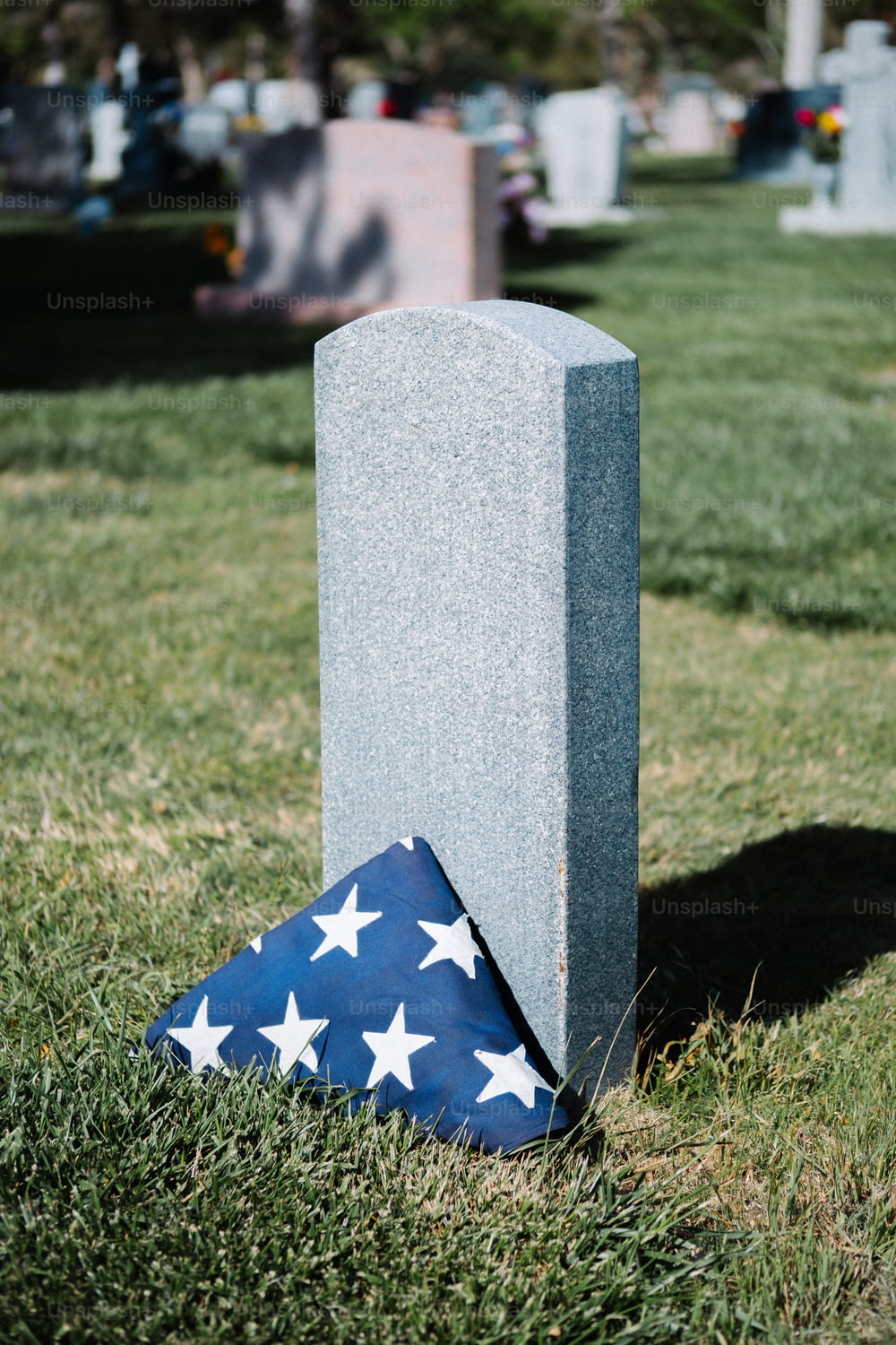 un drapeau posé sur une tombe dans l’herbe