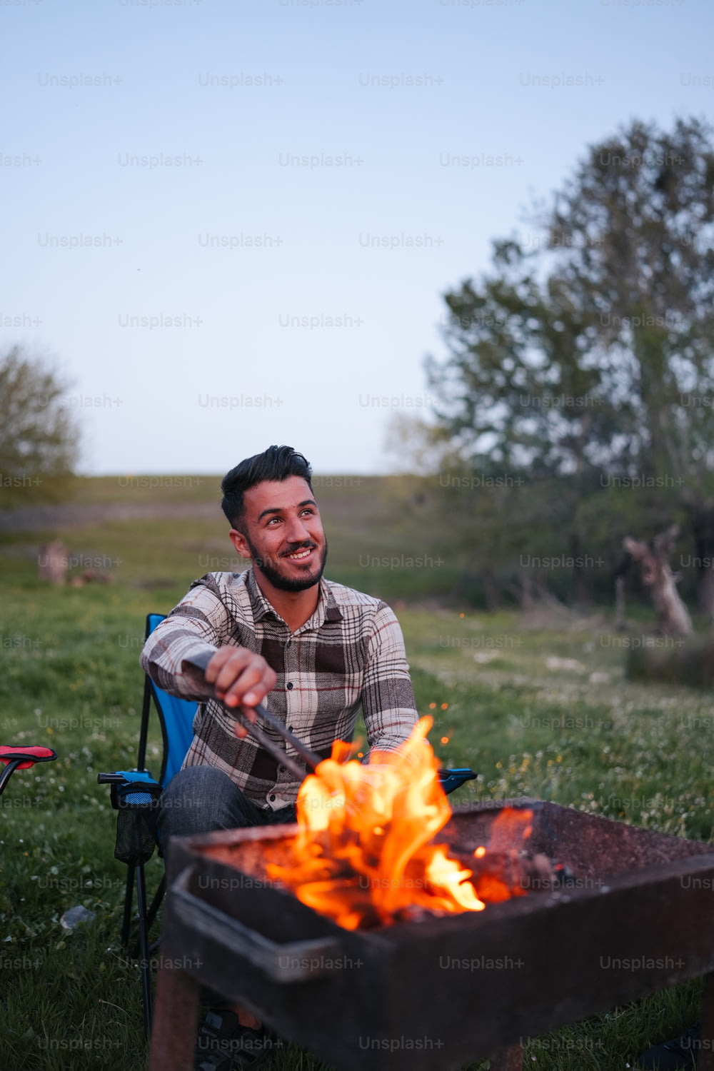 a man sitting in a chair next to a fire
