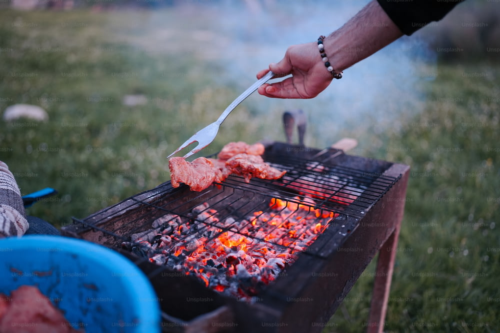a person is cooking food on a grill