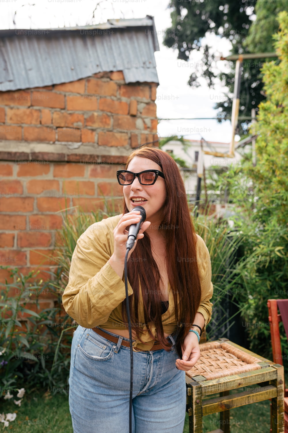 Una donna con gli occhiali sta cantando in un microfono