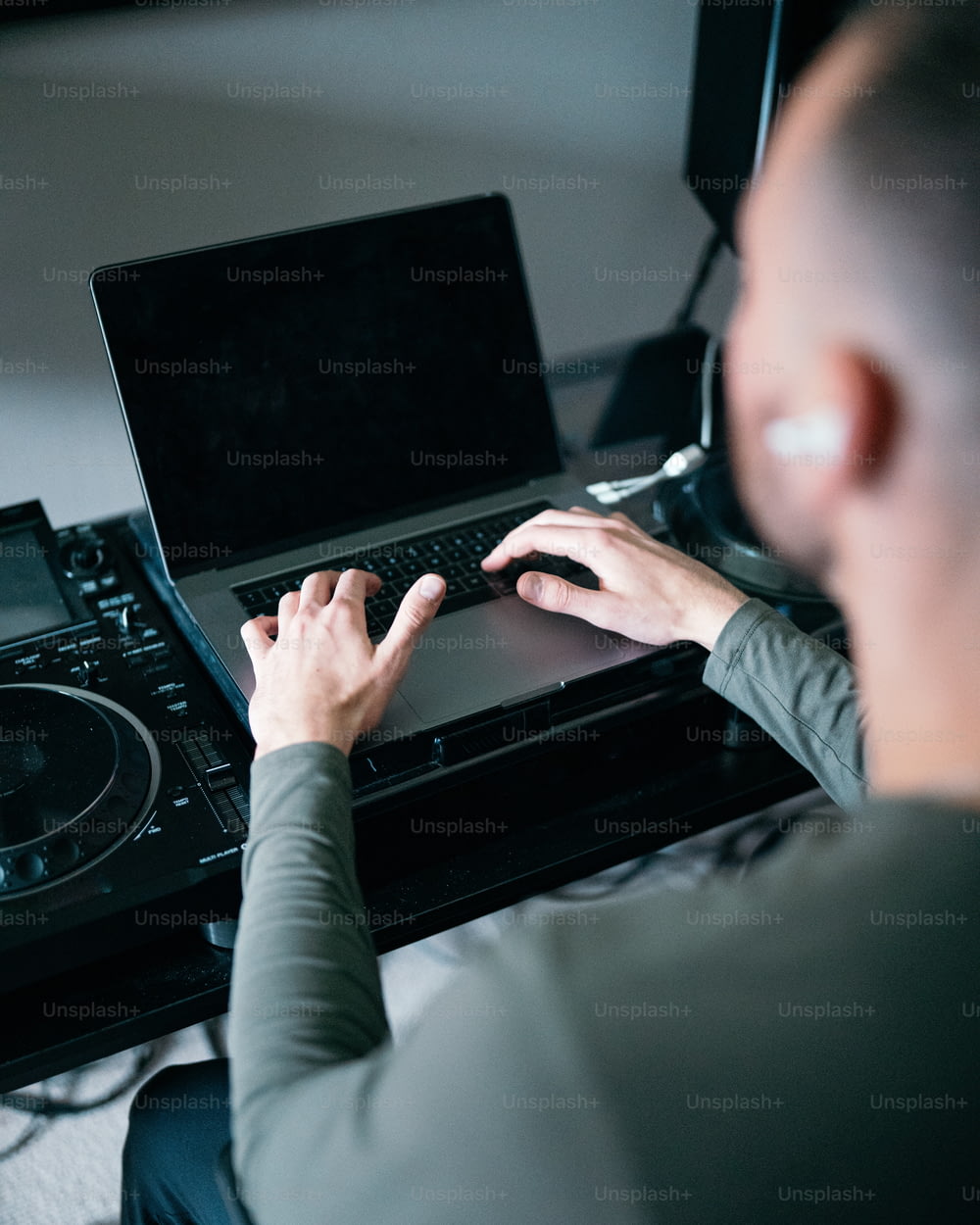 a man using a laptop computer on top of a turntable