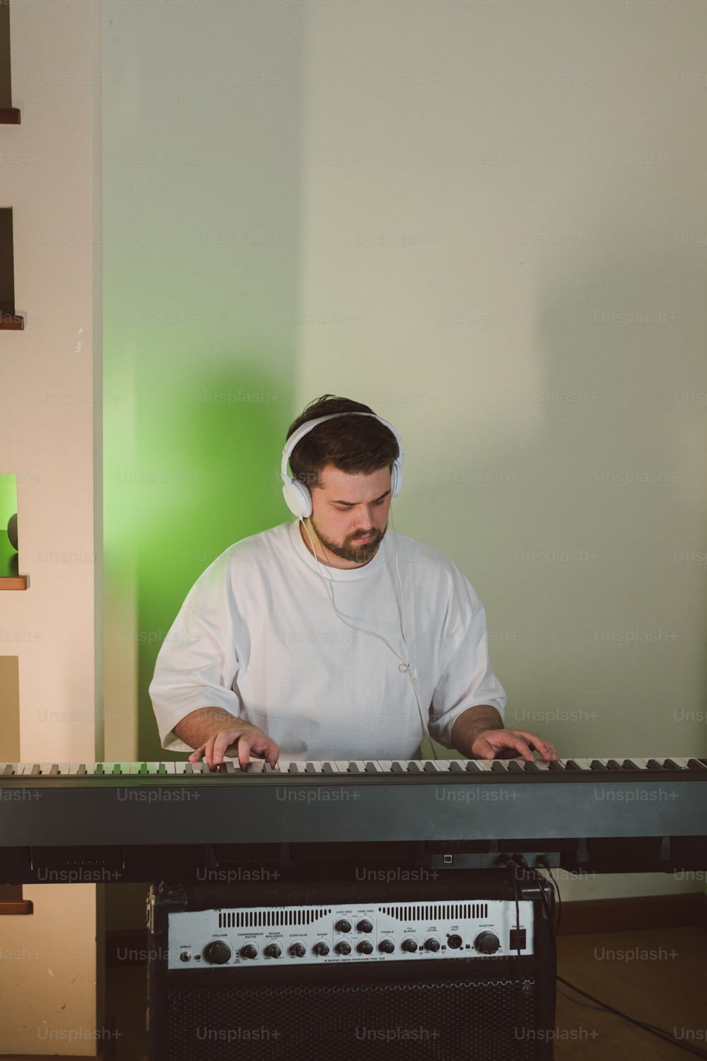 a man in a white shirt is playing a keyboard