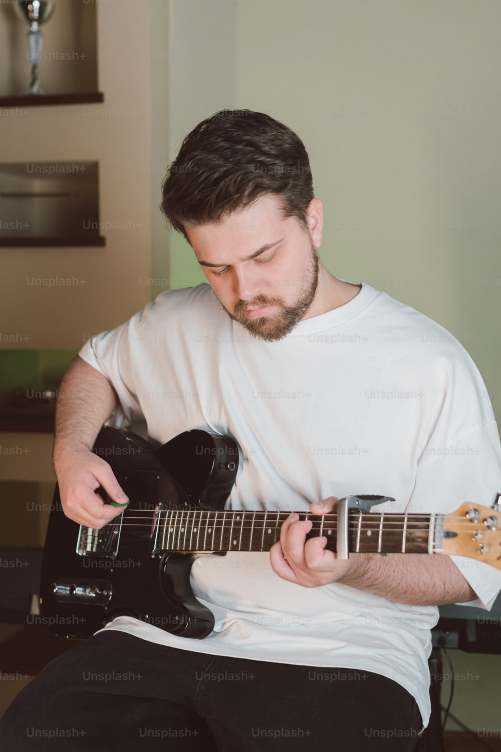 Un hombre tocando una guitarra en una habitación