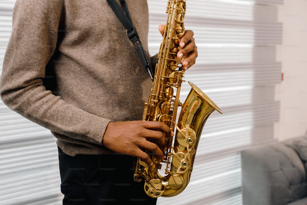 Ein Mann, der ein Saxophon in der rechten Hand hält