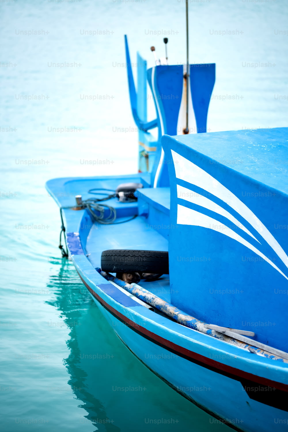 una piccola barca blu che galleggia sulla cima di uno specchio d'acqua