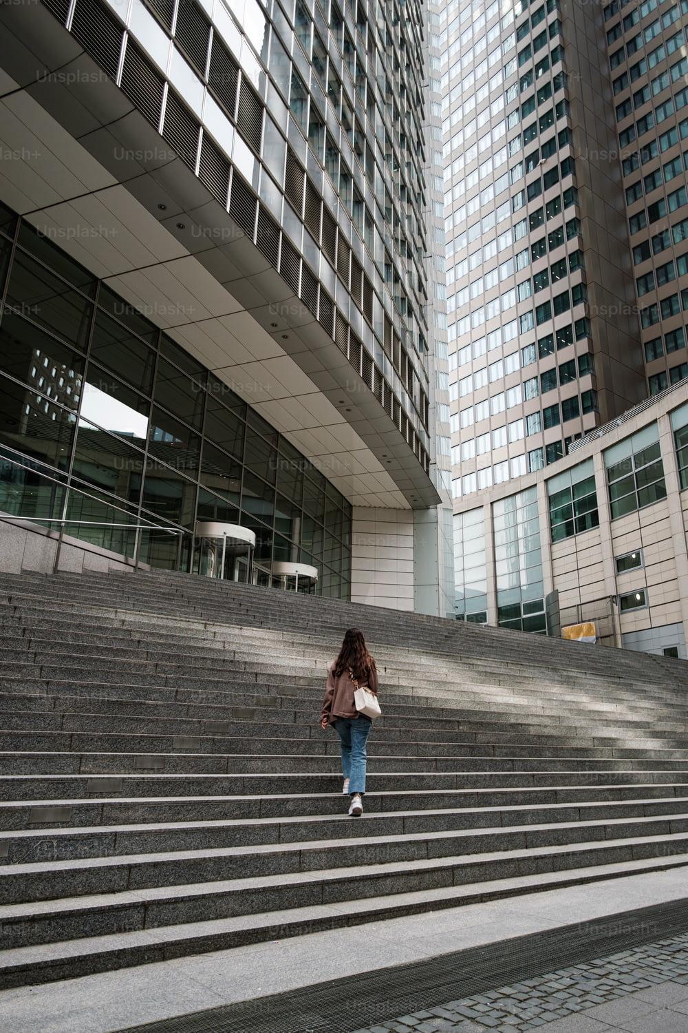 Una mujer subiendo unos escalones frente a un edificio