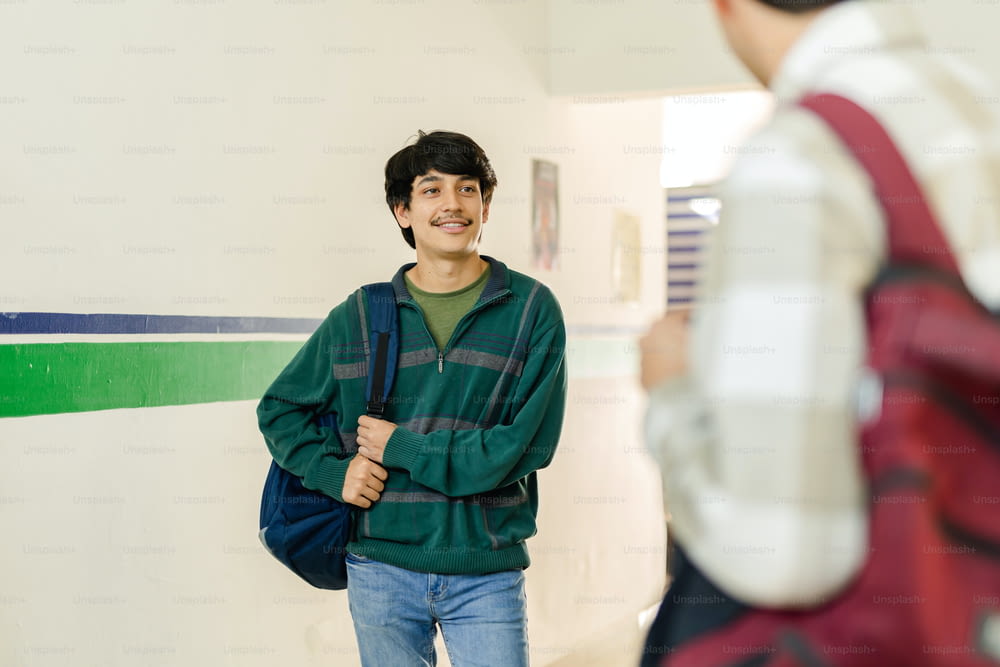 a man standing in a hallway with a backpack