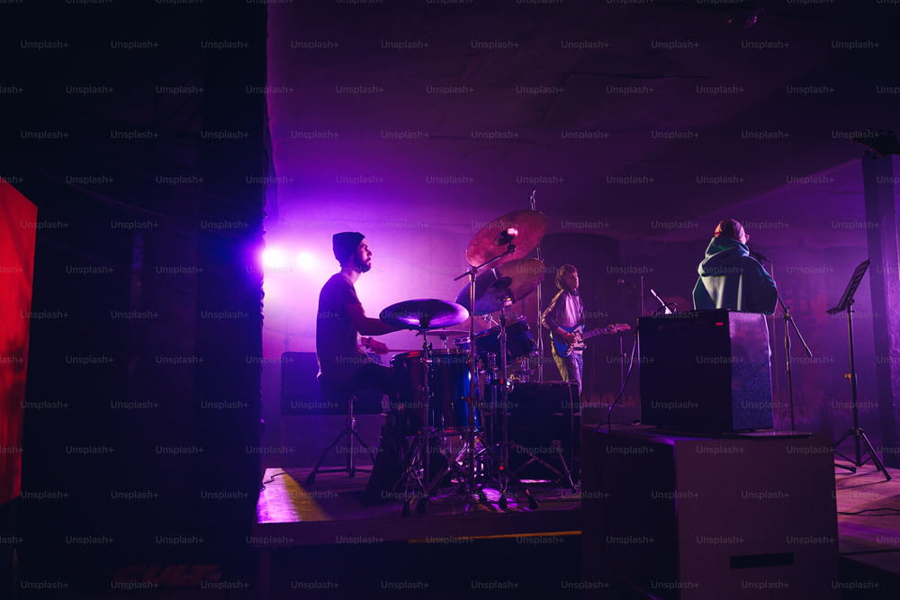 a band playing on stage in a dark room