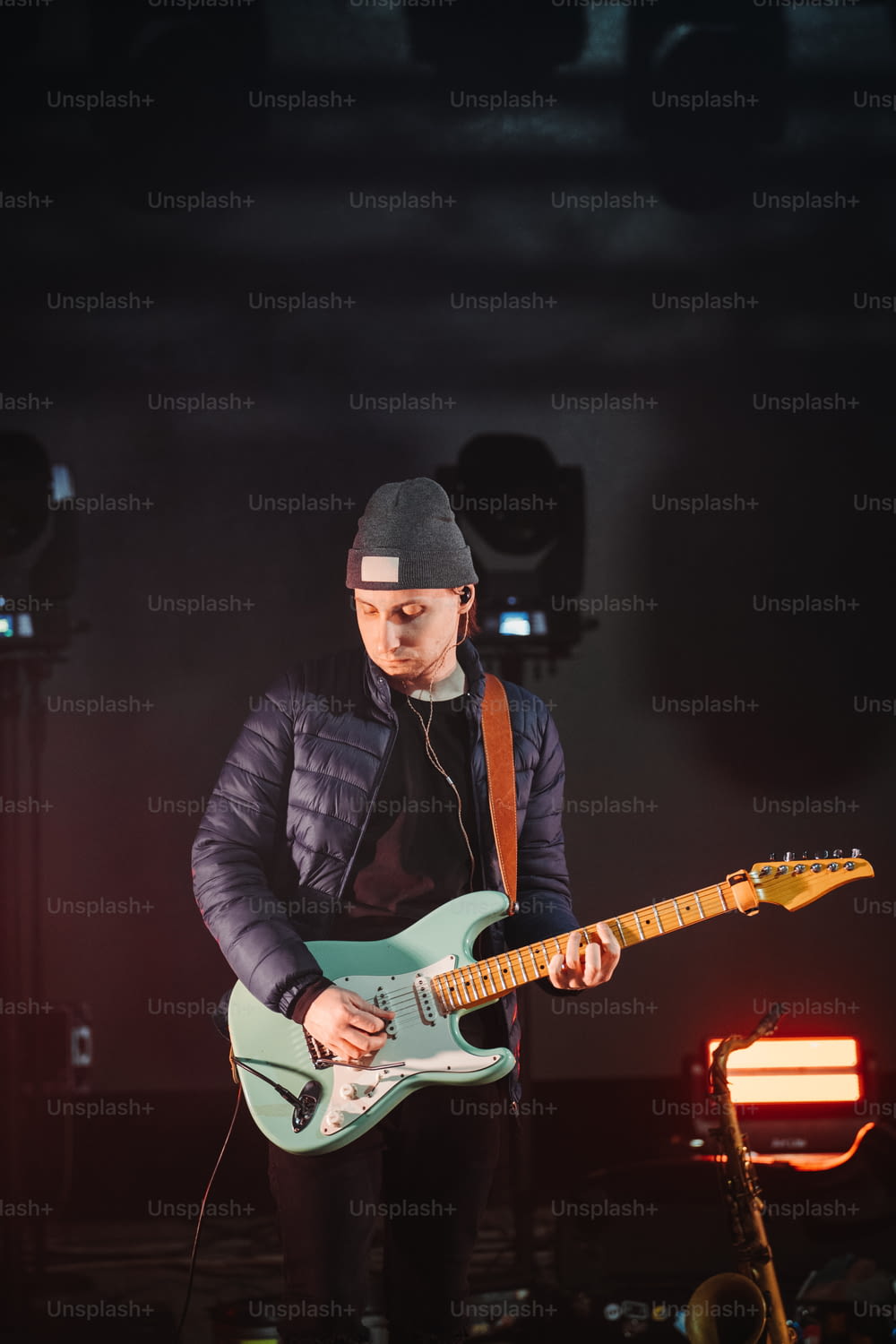 Un homme jouant de la guitare sur scène lors d’un concert