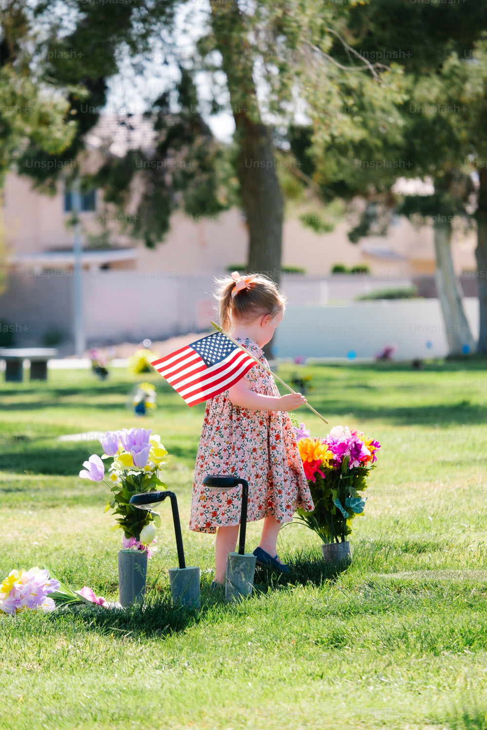 Ein kleines Mädchen, das eine amerikanische Flagge auf einem Feld hält