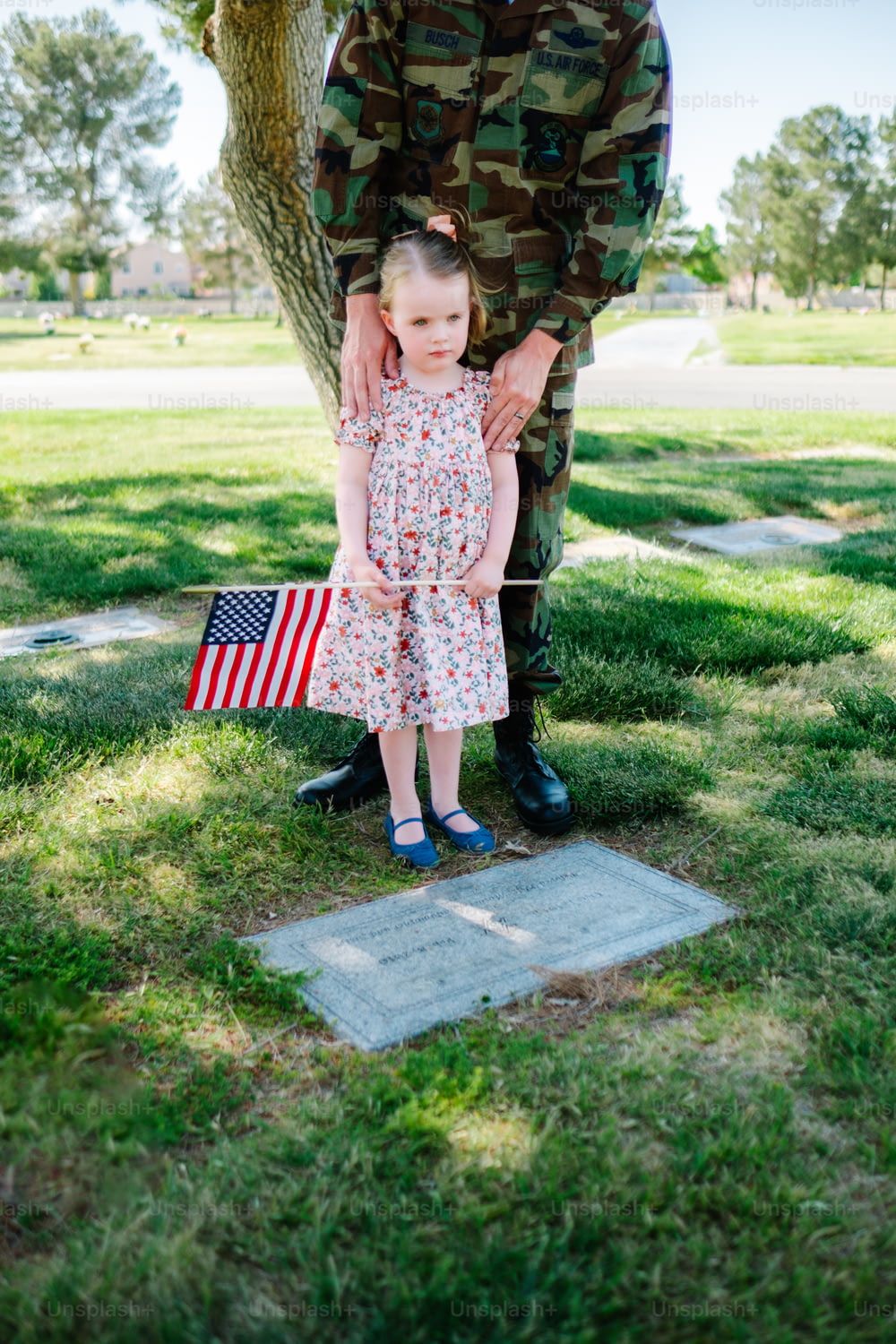 アメリカの国旗を持�つ兵士の隣に立っている少女