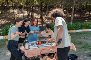 a group of people standing around a table with food on it