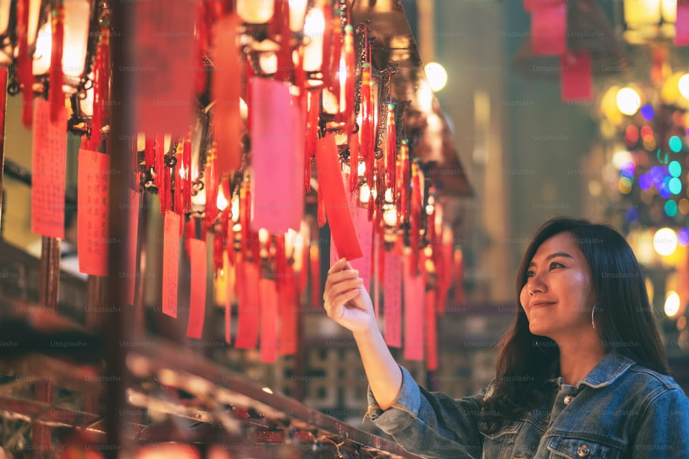Uma bela mulher asiática gostava de olhar para lâmpadas vermelhas e desejos no templo chinês
