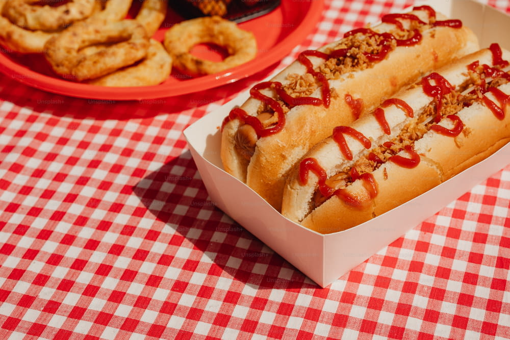un paio di hot dog seduti sopra un tavolo