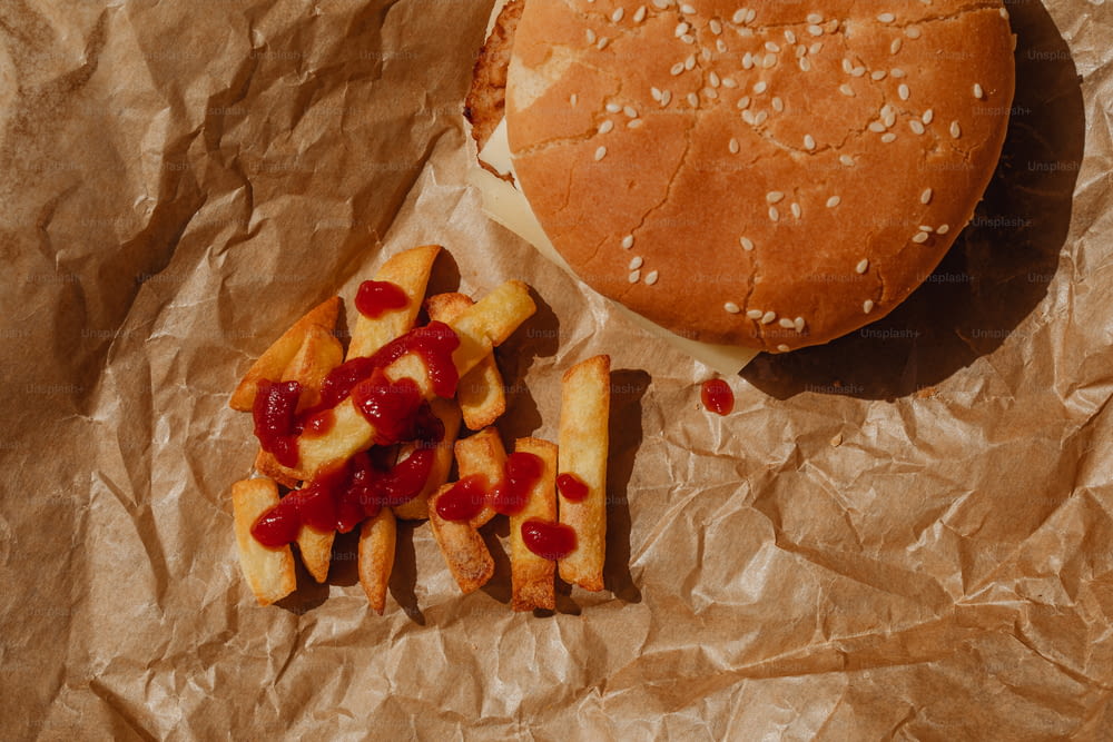 un hamburger e patatine fritte su un pezzo di carta cerata