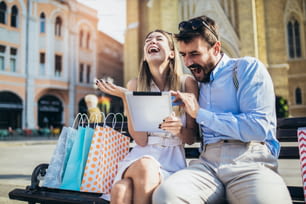Junges Paar mit einem digitalen Tablet für Online-Shopping im Freien.
