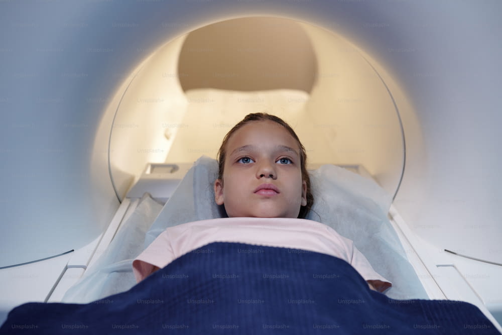 診療所や医療検査室でMRIスキャン手術を受けている現代の少女