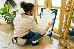 Vista posteriore di un giovane creativo di 20 anni che prende una lezione di pittura in un laboratorio