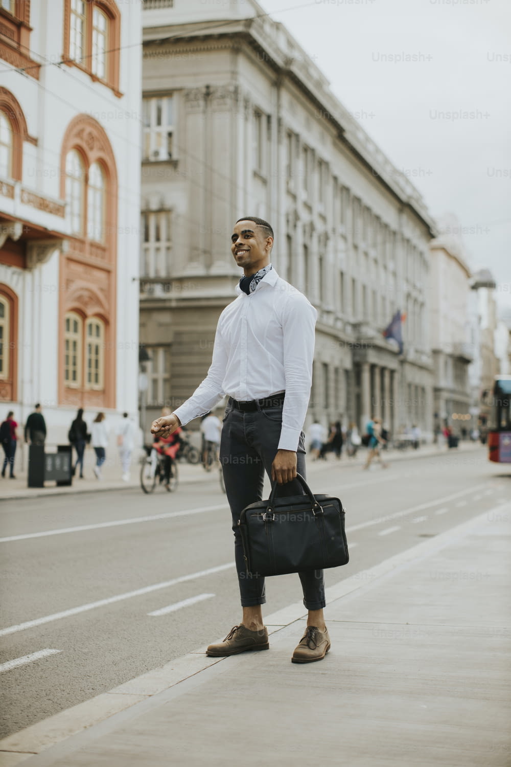 Handsome young African American businessman waitng a taxi on a street