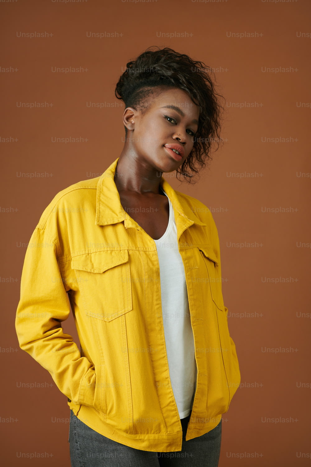 Ritratto di giovane donna nera fiduciosa in giacca gialla di jeans che guarda la macchina fotografica