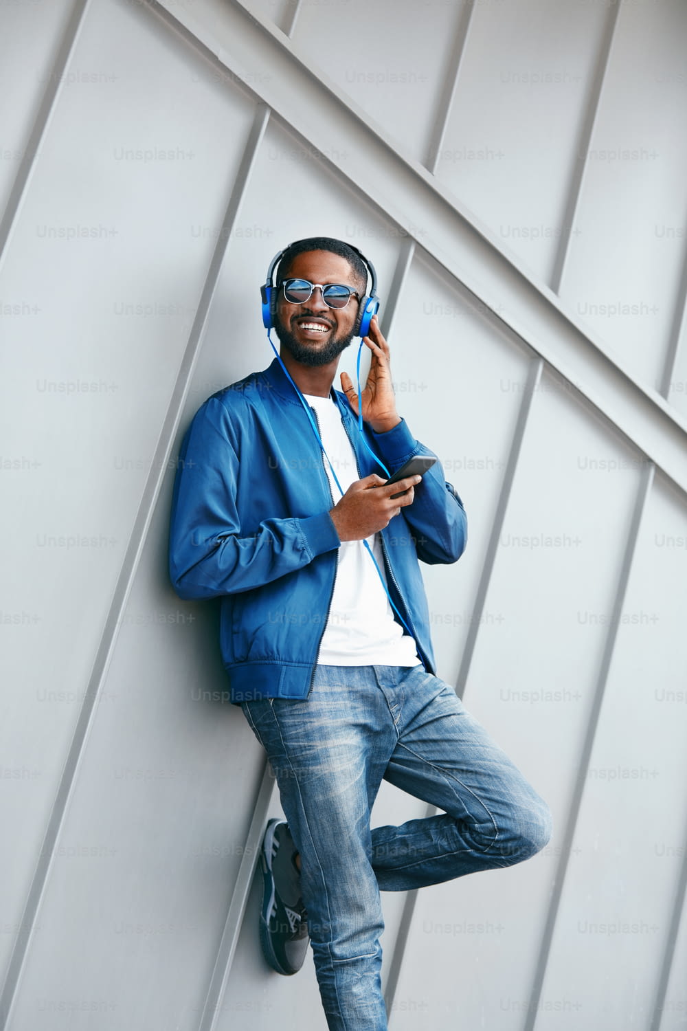 Man Listening Music In Headphones On Phone In Street. Handsome Black Male In Fashion Clothes. High Resolution