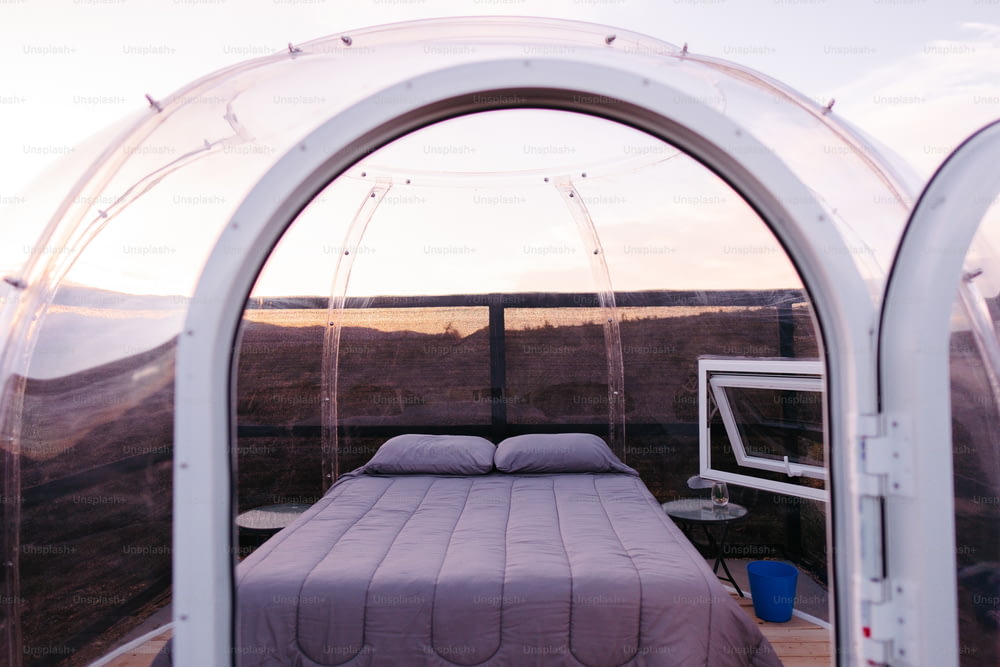 un letto seduto all'interno di una tenda accanto a una finestra