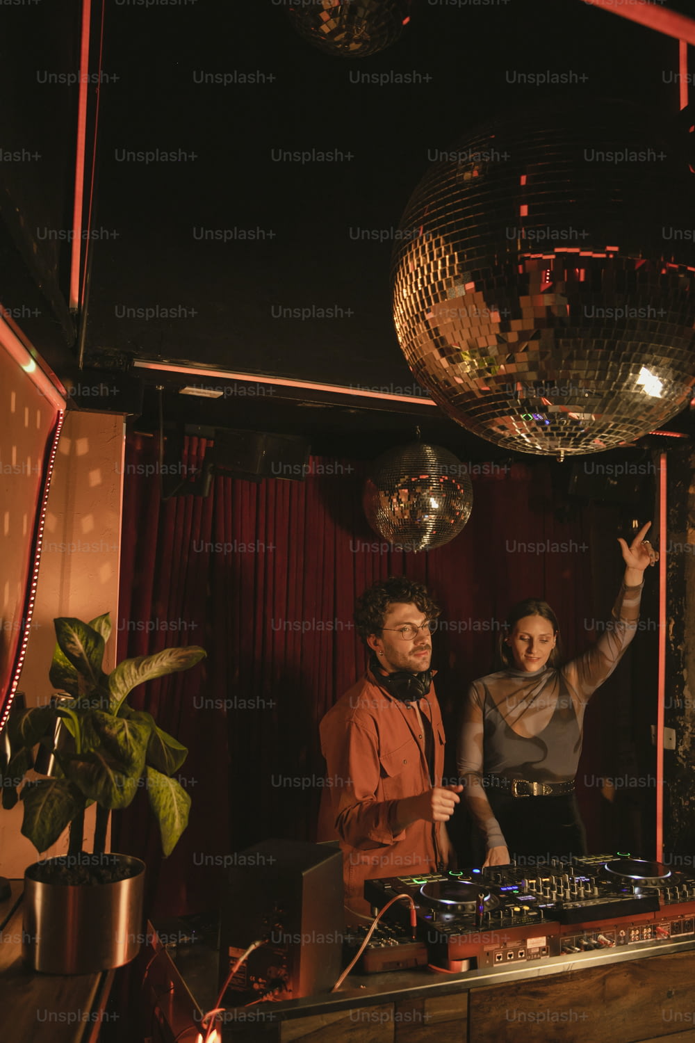 a man and a woman standing in front of a disco ball