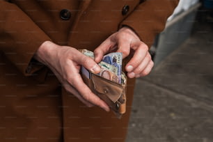 a person in a brown coat holding a wallet