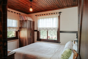 un dormitorio con una cama y dos ventanas