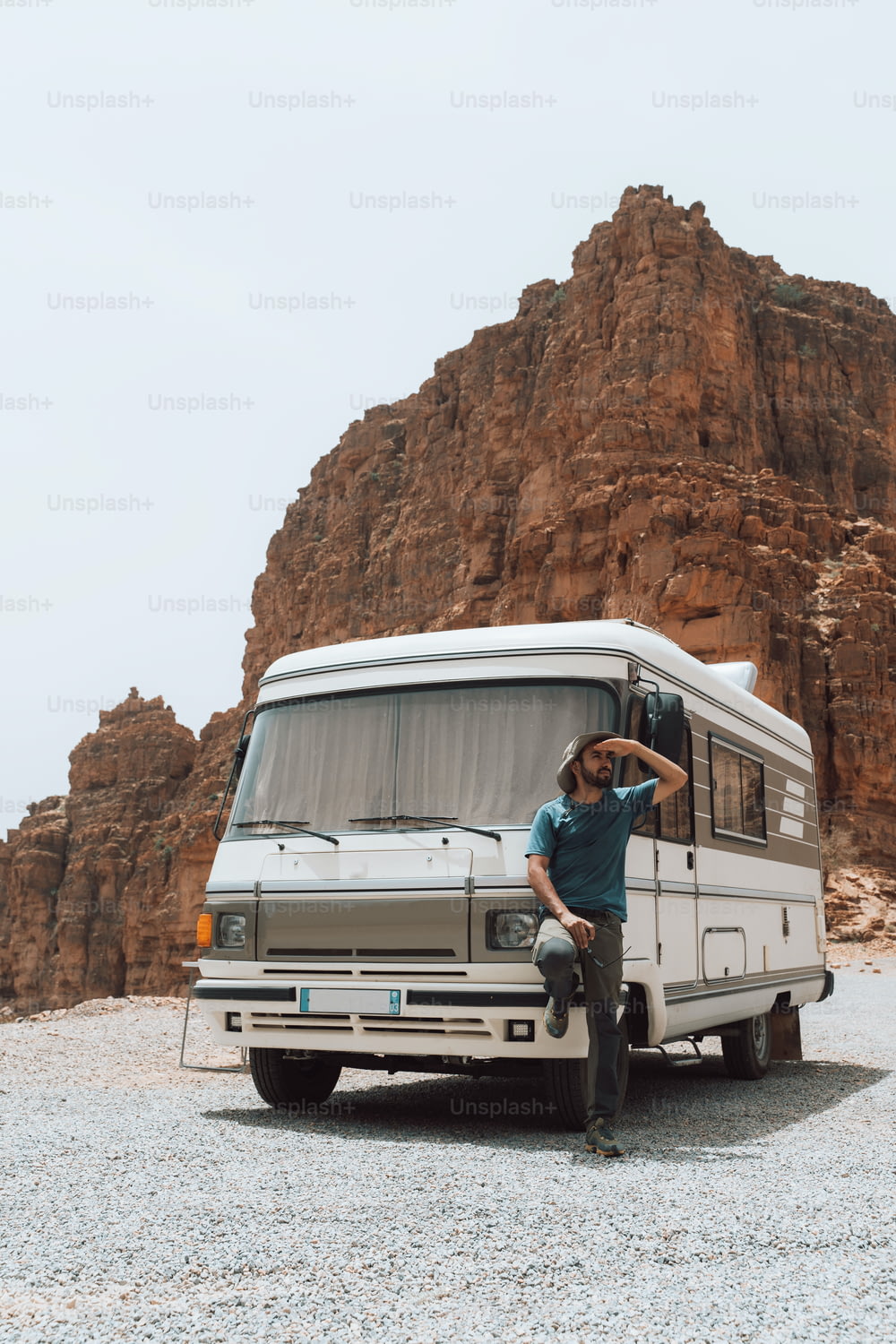 Un uomo seduto sulla parte anteriore di un furgone di fronte a una montagna