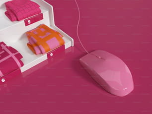um mouse de computador sentado em cima de uma superfície rosa