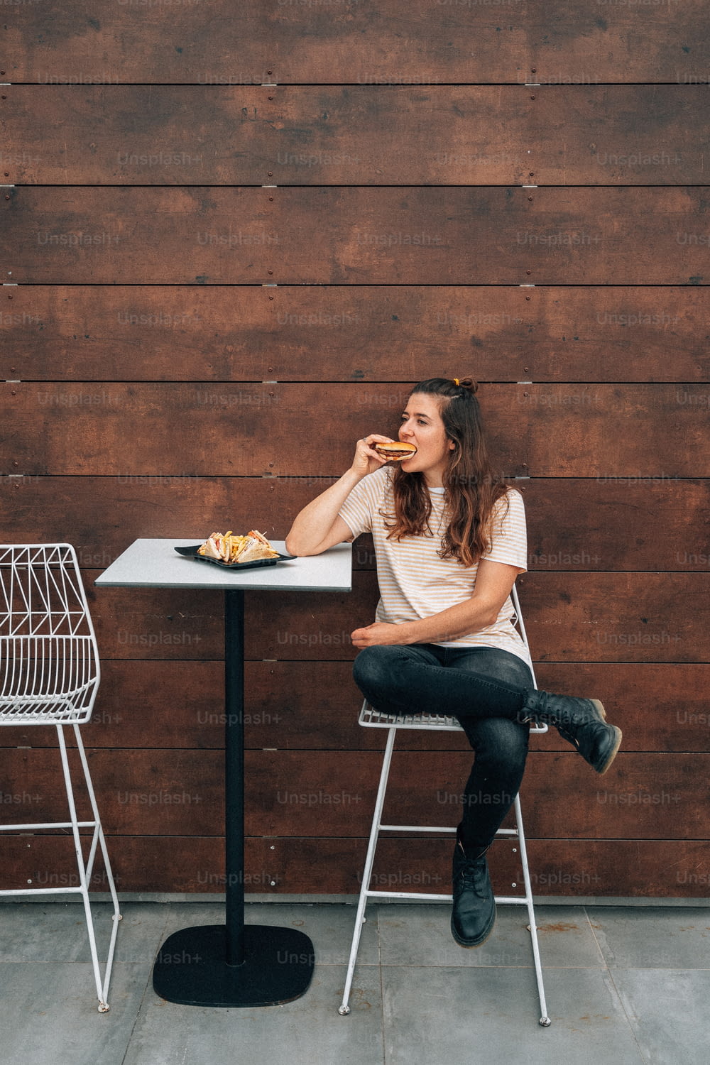 uma mulher sentada em uma mesa comendo comida