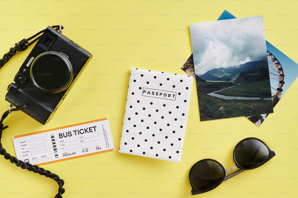 여권, 선글라스, 카메라, 노란색 배경의 티켓